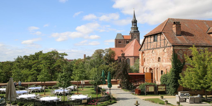 Historic wedding location Alte Kanzlei with event garden for the dream wedding. In the background is the St. Stephen's Church, a landmark in the city of Tangermünde.