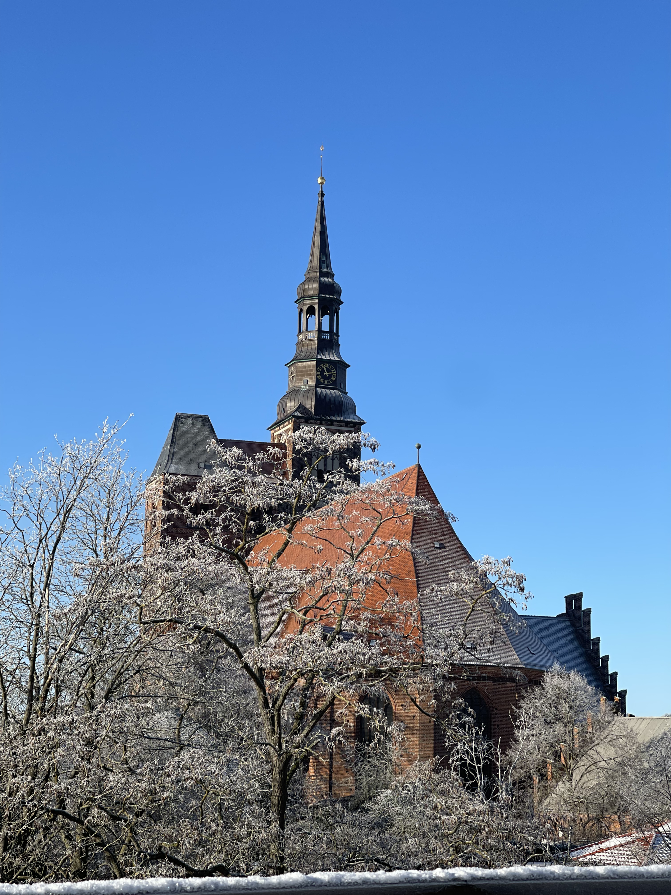 Blick auf die Sankt Stephanskirche im Winter. Blauer Himmel im Hintergund.