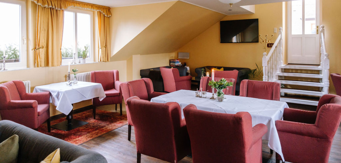 Ansicht Clubzimmer mit Sitzgruppen und Blick zum Treppen-Ausgang. hotel-schloss-tangermuende-clubzimmer_5.jpg